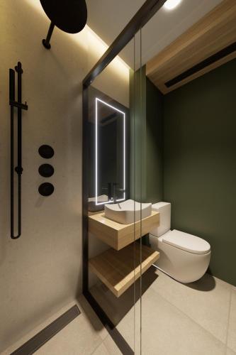 a bathroom with a toilet and a sink and a mirror at Hospedium GL Hotel Andújar in Andújar