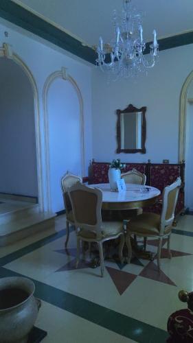 a dining room with a table and chairs and a chandelier at Casa Di Bella Taormina in Roccalumera