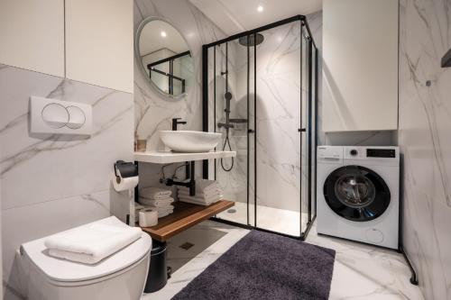a bathroom with a sink and a washing machine at Amfora-modern apartments with pool in Makarska