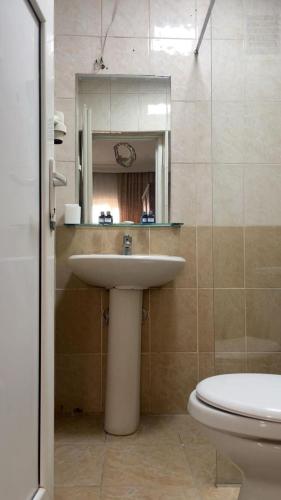 a bathroom with a sink and a toilet and a mirror at Kenedi Otel in Altındağ