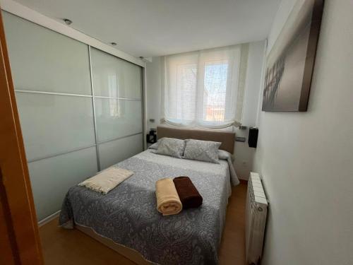 a bedroom with a bed with two towels on it at Atico en el centro de Vitoria Parking gratis in Vitoria-Gasteiz