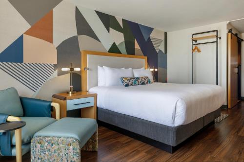 a hotel room with a bed and a chair at Hotel Mockingbird, Dallas, a Tribute Portfolio Hotel in Dallas