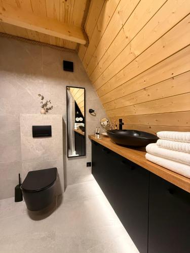 a bathroom with a black toilet and a sink at Lune Dunakanyar in Esztergom