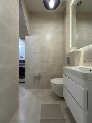 a bathroom with a white toilet and a sink at Luxe House Odessa Private Jacuzzi BBQ, Free Parking in Odesa