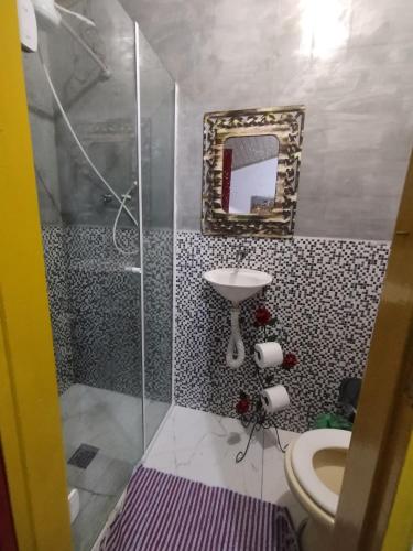 a bathroom with a shower and a toilet and a mirror at Casinha Centro histórico in Paraty