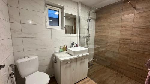 a bathroom with a toilet and a sink and a shower at Little H Family in Dealu Mare