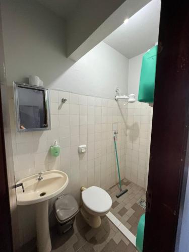 a bathroom with a sink and a toilet and a tv at BG Hospedagens in Paracatu