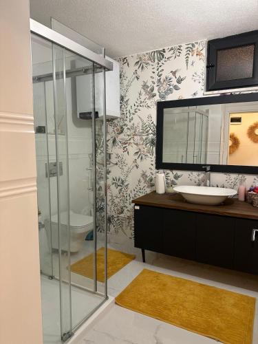 a bathroom with a glass shower and a sink at Çambaşı Villa Bella in Ordu