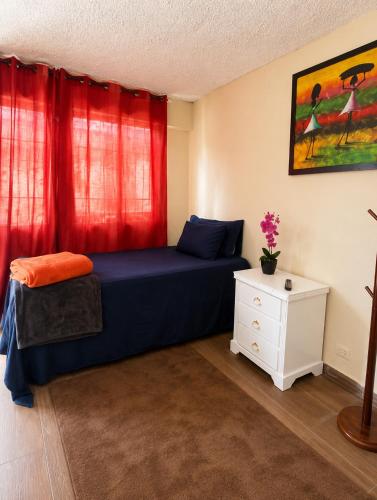 a bedroom with a blue bed with red curtains at Hotel restaurant bon Appetit in Santa Cruz de Barahona