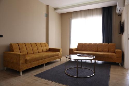 a living room with two couches and a table at Gold Apart Otel in Mersin