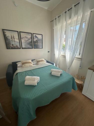 a bedroom with a bed with two towels on it at Maris Home in Luino
