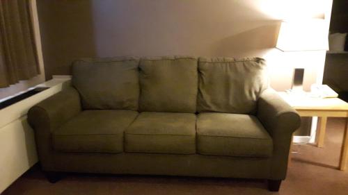 a couch in a living room with a table at Canway Inn & Suites in Dauphin