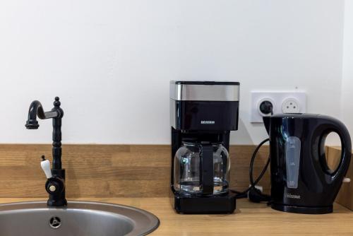 a coffee maker sitting on a counter next to a sink at Le Container de Jeff - Maison bois, grand jardin in Uzel