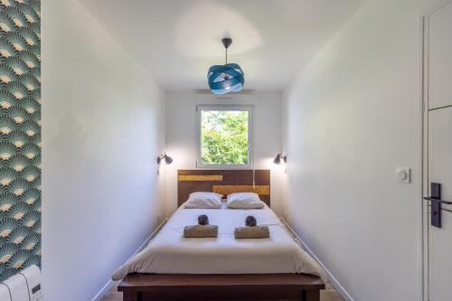 a bedroom with a bed and a window at Le Container de Jeff - Maison bois, grand jardin in Uzel
