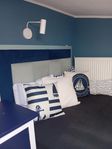 a room with blue walls and white pillows at Sweet Hampton w Kacku in Gdynia