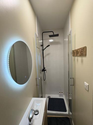 a bathroom with a sink and a shower with a mirror at Studio cosy - inspiré de Capri in Bar-le-Duc