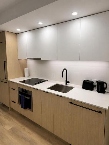 a kitchen with white cabinets and a sink at Executive suite in Surrey