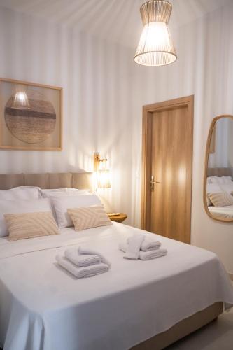 a bedroom with a white bed with towels on it at Boho Nook Apartment in Rethymno