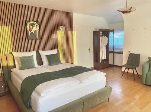 a bedroom with a large bed and a chair at Cosy Carré in Sélestat