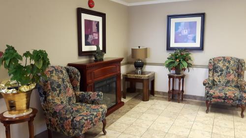 a living room with two chairs and a fireplace at Canway Inn & Suites in Dauphin