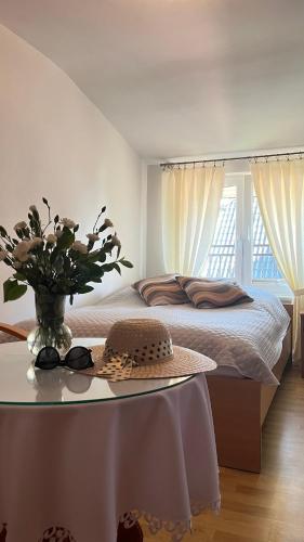 a bed with a table with a hat and glasses on it at Jagienka in Łeba