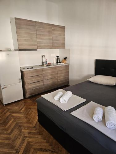 a room with two beds and a refrigerator and a kitchen at Sonček 2 in Izola
