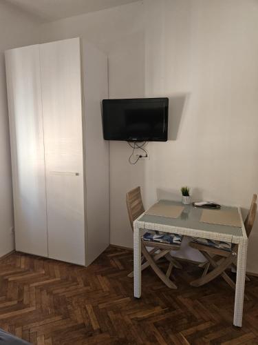 a small room with a table and a tv on a wall at Sonček 2 in Izola