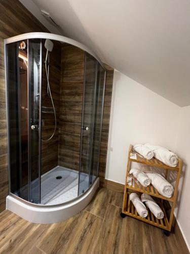 a shower in a bathroom with a wooden floor at Lukas Hotel in Muravitsa