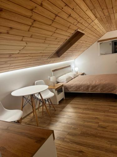 a bedroom with a bed and a table and chairs at Lukas Hotel in Muravitsa