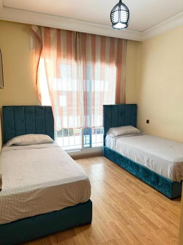 a room with two beds and a window at super appartement centre avec parking in Tangier