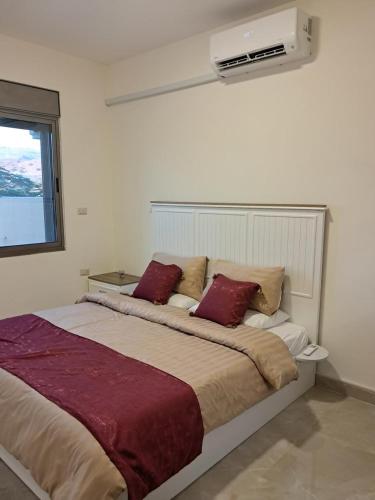 a bedroom with a large bed with red pillows at Muzn al Ghaith Luxury Chalet with Private Pool in Ash Shāghūr