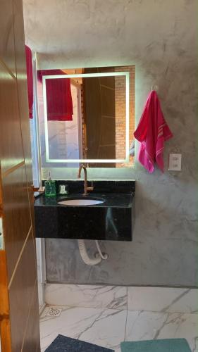 a bathroom with a sink and a mirror at Chalé Suíça da Serra in São Benedito