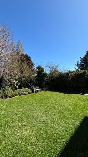 a park with a bench in the middle of a field at Periko´s Youth Hostel in San Carlos de Bariloche