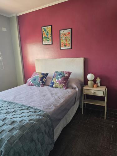 a bedroom with a bed and a red wall at NAT home in San Lorenzo