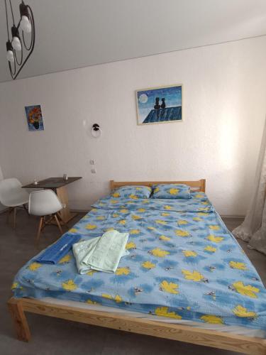 a bedroom with a bed with a blue comforter at Жилье у моря in Odesa