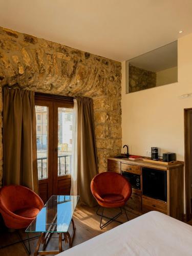 a room with two chairs and a glass table in a room at Apartamentos El Capitan in Potes