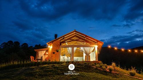 a house on a hill at night with lights at Chalé Caminho do Sol in Rancho Queimado