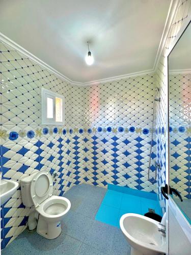 a blue and white bathroom with a toilet and a sink at اقامة الابرار in Oued Laou