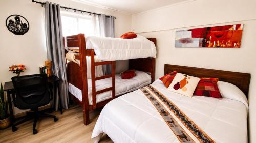 a bedroom with two bunk beds and a desk at Milagro Andino in Arica