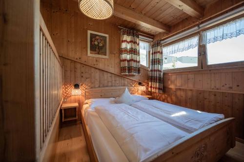 a bedroom with a large bed in a room with windows at Ciasa Cianins in San Vigilio Di Marebbe