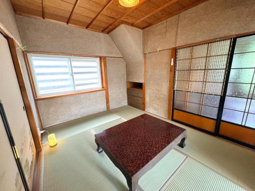 a small room with a table and a window at 長峰駅から徒歩3分ゲストハウスオオワニ in Ōwani