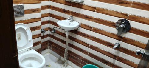 a bathroom with a toilet and a sink at Hotel Golden Spark in Jewar