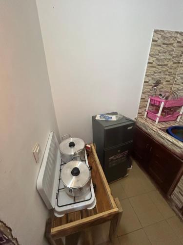 a small kitchen with a stove and a sink at Résidence ivoire in Yamoussoukro