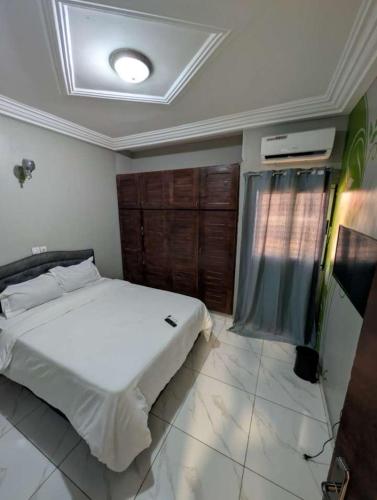 a bedroom with a white bed in a room at Résidence ivoire in Yamoussoukro
