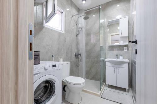 a bathroom with a washing machine and a shower at Apartmani Oleander in Bar