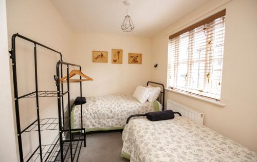 a bedroom with two beds and a window at 2 Crown Barton in Glastonbury