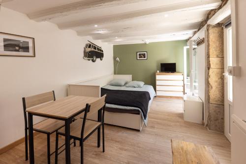 a small bedroom with a bed and a table at Le Patio in Gevrey-Chambertin