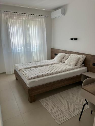 a large bed in a bedroom with a window at Villa Elaris in Bihać