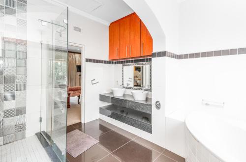 a bathroom with two sinks and a shower at Bryanston stays in Johannesburg