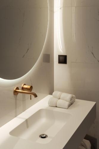 a white bathroom with a sink and a mirror at The View at the Downtown 5 in Faro